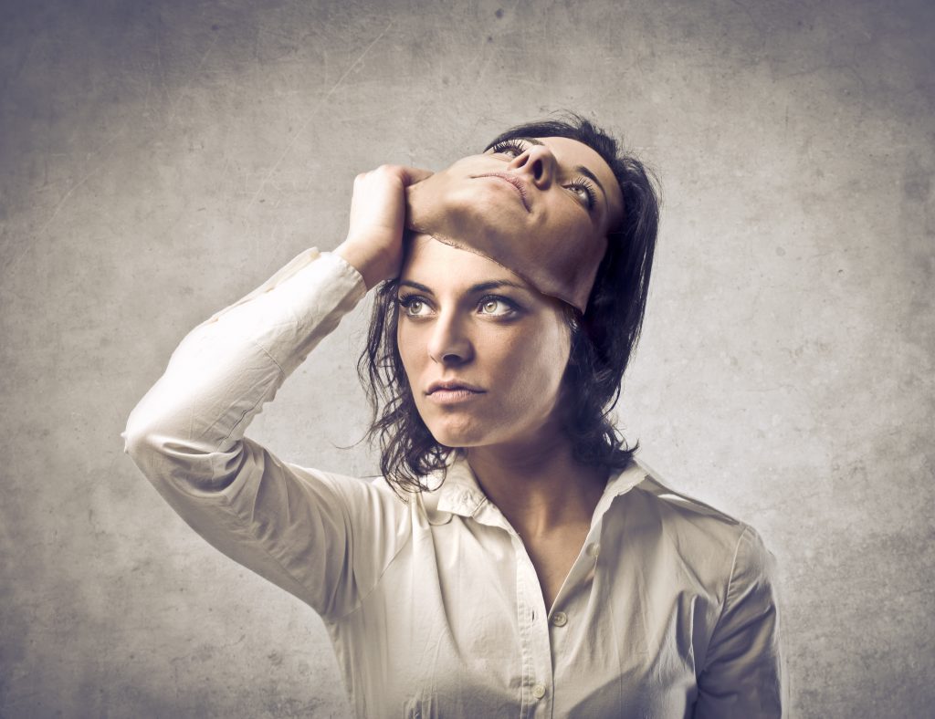 Woman removing mask that looks exactly like her real face